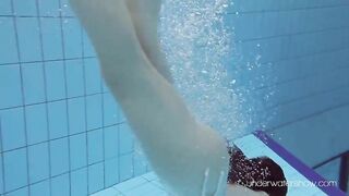 Floating babe in the warm pool getting naked