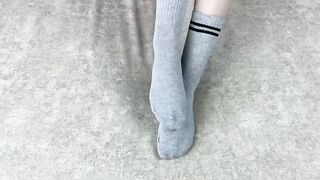 Solo caressing girl in gray cotton socks on the sofa