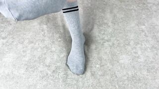Solo caressing girl in gray cotton socks on the sofa