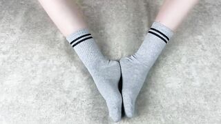 Solo caressing girl in gray cotton socks on the sofa